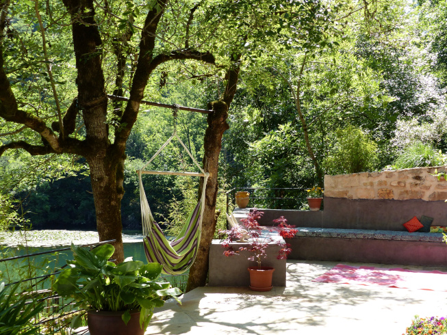 a hammock hanging on the terrace overlooking the weir